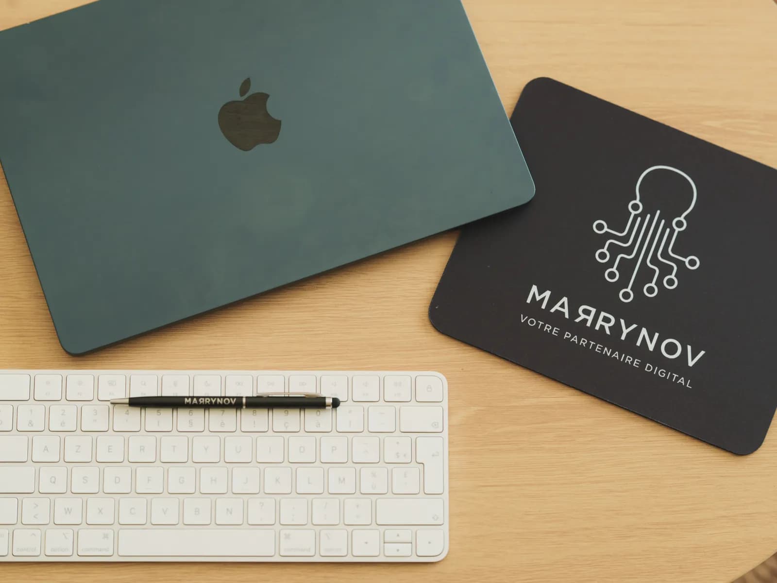 Détail du setup MARRYNOV : clavier, stylo et tapis de souris brandés